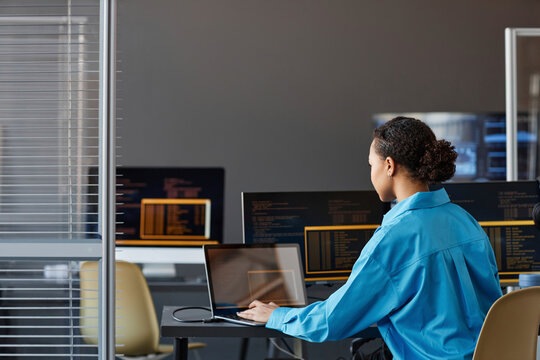 Computer programmer working on laptop in office