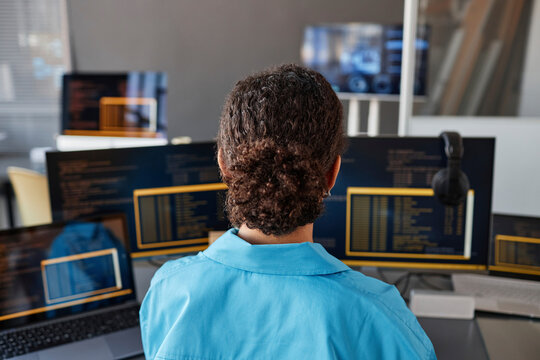 Young computer programmer working on desktop PCs