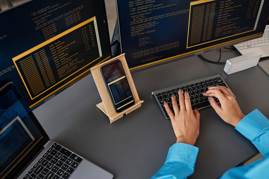 Hands of computer programmer typing on keyboard at desk