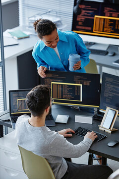 IT professional discussing over desktop PC with colleague