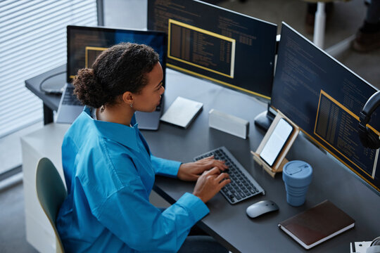 IT professional typing on keyboard and using computer at desk