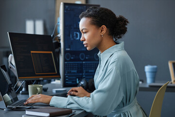 Young computer programmer working on laptop in office