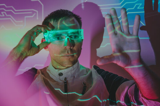 Man wearing smart glasses and gesturing in neon lights