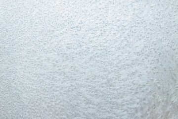 frosty winter window with ice patterns full frame. winter white background, frost on window