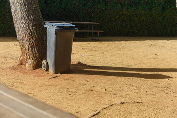 Park, dining tables, sand, trees, garbage, garbage can