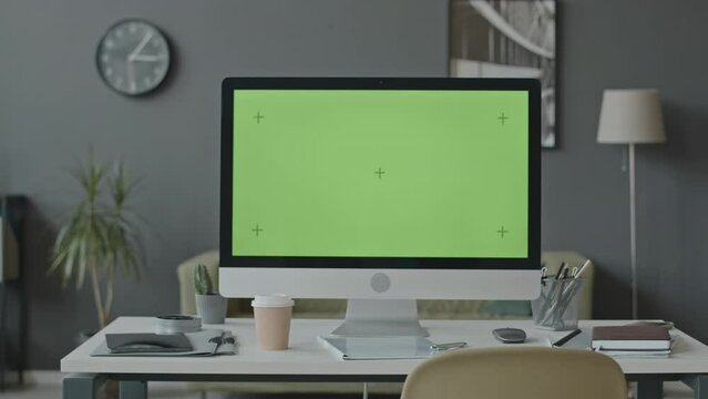 No people shot of computer monitor with chroma key green desktop screen on white desk at modern office