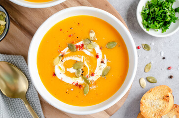 Pumpkin Soup, Tasty Homemade Pumpkin, Sweet Potato, Carrot Soup in a Bowl on Bright Background