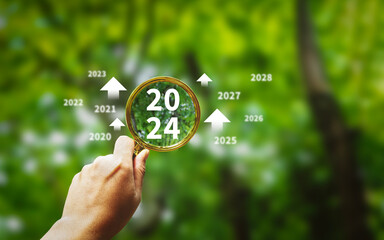 magnifying glass with 2024 icon, new year beginning concept business focus caring for the...