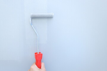 painting a wall, hand with roller