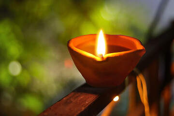 selective focus. clay diya lamps lit during diwali celebration. Lit diya lamp on street at night or...