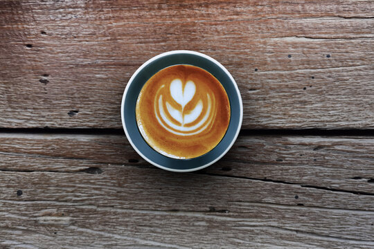 a cup of latte art coffee on wooden background                                                                                                                                                          