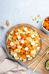 Pasta with Roasted Pumpkin, Farfalle Pasta with Pumpkin and Feta on a Plate on Bright Background