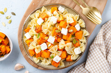 Pasta with Roasted Pumpkin, Farfalle Pasta with Pumpkin and Feta on a Plate on Bright Background
