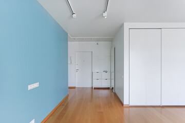 frontal shot on the interior of an empty living room without furniture and people, white walls,...