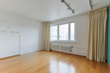 view of an empty room without furniture for rent or sale, white walls, large window with curtains
