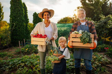 Happy family done with harvesting vegetables and smiling