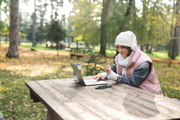 Obraz premium Freelancer working on laptop in autumn park