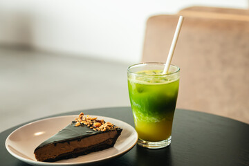 Lemonade and a piece of chocolate cake on a table in a cafe interior.