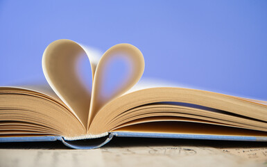Heart from a book page on blue background, book of love