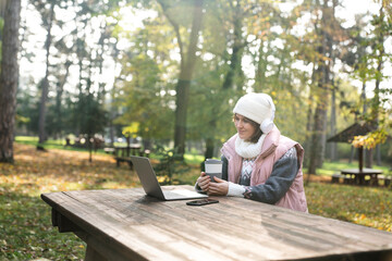 Fototapeta premium Freelancer working on laptop in autumn park