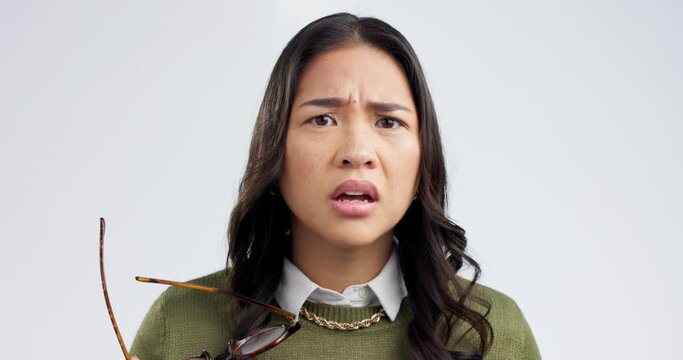 Confused, face and woman in studio with glasses for choice, decision or ask on grey background space. Portrait, wtf and asian female model with questions, doubt and why emoji for omg, thinking or huh