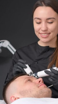 A female cosmetologist performs a cavitation procedure. Vertical video