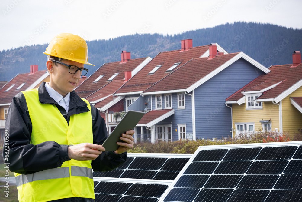 Poster Engineer with tablet computer on a background of mobile solar energy power station.