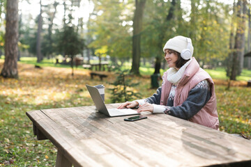 Obraz premium Freelancer working on laptop in autumn park