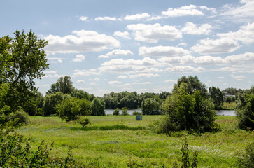 Fototapeta premium Summer landscape with river and blue sky with white clouds in sunny day