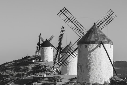 Mills in the town of Consuegra. Landscape of several white windmills and brown windmills on the hill. ancient architecture. Farm houses.