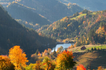 Fototapeta na wymiar Autumn landscape with lake and country houses in mountains