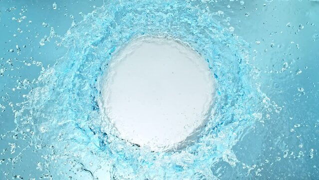 Super Slow Motion Shot of Round Water Splash on Light Blue Background at 1000fps.