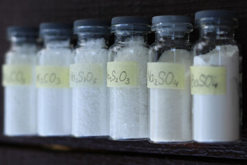 White crystalline inorganic substances - various salts in glass tubes.