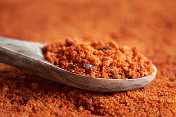 Sea buckthorn powder with seeds on a wooden spoon, close up