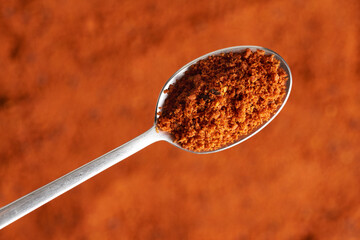 Sea buckthorn powder with seeds on a metal spoon