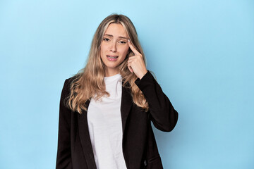 Caucasian woman in business jacket showing a disappointment gesture with forefinger.