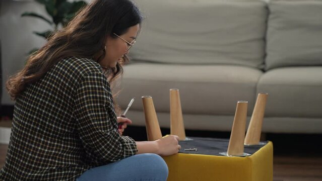 Asian Woman self repairs furniture renovation using equipment to diy repairing furniture.