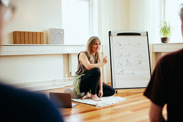Yoga teacher talking with students in class