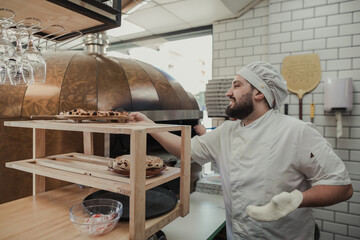 Man working inside the kitchen of a pizzeria restaurant - obrazy, fototapety, plakaty