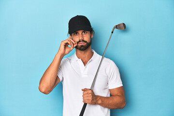 Long-haired golfer with club and hat with fingers on lips keeping a secret.