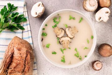 Homemade mushroom soup in a bowl on a gray background.