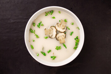 Homemade mushroom soup in a bowl on a dark background.