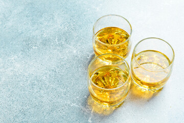 Whiskey in a glass. Glasses with whiskey or bourbon on a concrete background. Strong aged alcoholic...