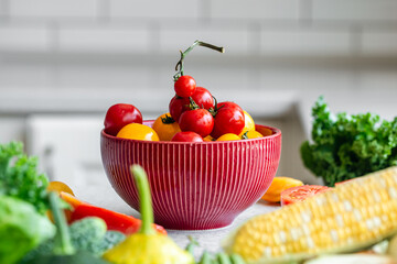 Close-up, a bowl of ripe red and yellow tomatoes on the kitchen table.