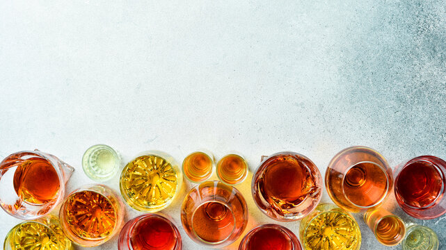 Assortment of alcoholic beverages: vodka, cognac, tequila, scotch, brandy and whiskey, grappa, liqueur, vermouth, tincture, rum. Strong alcoholic drinks. On a stone background.