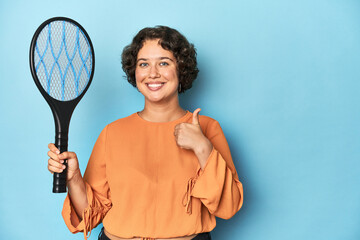 Young woman with electric mosquito racket Young woman with electric mosquito racketsmiling and...