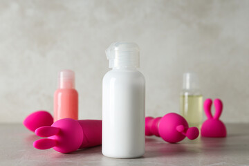 Lubricant in a white bottle and toys for sex - obrazy, fototapety, plakaty