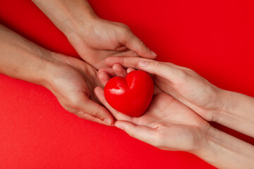Red heart in arms on a red background. Blood donation