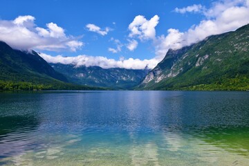 Scenic view of lake Bohinj and mountains in Julian alps above with the tops covered in clouds in Slovenia