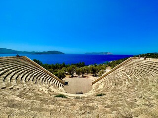 An antique amphitheater near a picturesque town with a beautiful view of the sea.